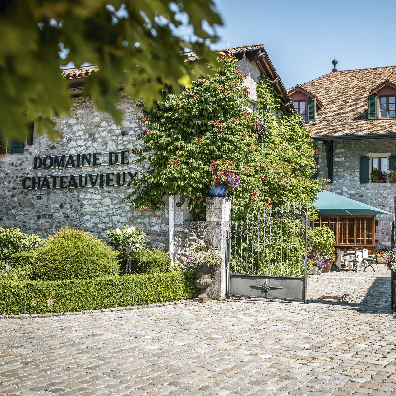 il cancello d'ingresso e il giardino anteriore del ristorante Domaine de Châteauvieux 